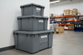Three heavy-duty industrial containment bins stacked in warehouse